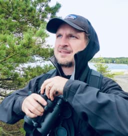 Marcus Rydling med kikare ute i naturen